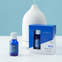 Capri Blue Blue Jean diffuser oil bottle and packaging on a light blue background
