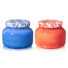 Two jars, one blue and one orange, with floral-patterned lids on a white background.