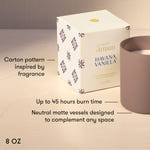 A 8 oz scented candle shown with its white patterned box and a matte taupe candle vessel on a light beige surface. Text on the image highlights the carton design inspiration, up to 45 hours burn time, and neutral matte vessel design.