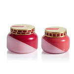 Two pink jars with gold lids on a white background