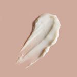 Close-up of a smear of white cream on a beige background