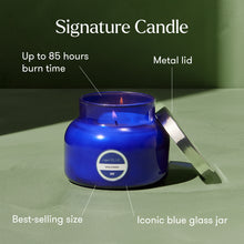 Blue candle in a glass jar with features highlighted on a green background