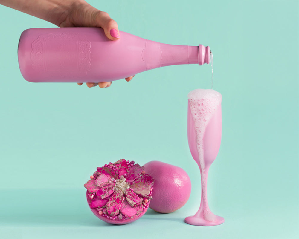 Pouring champagne into a pink glass