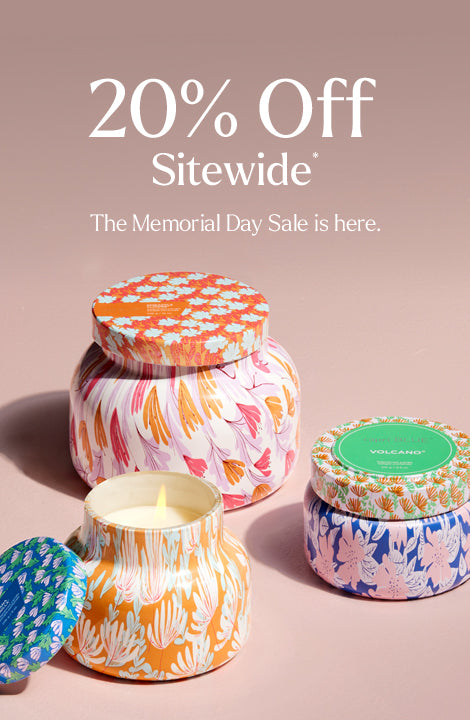 Decorative candles with colorful designs on a beige background, featuring a Memorial Day sale promotion.