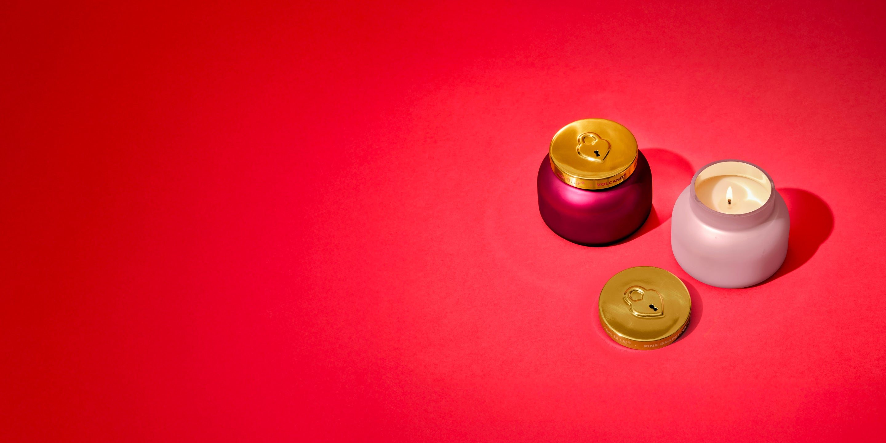 Two small candles with gold ids on a red background