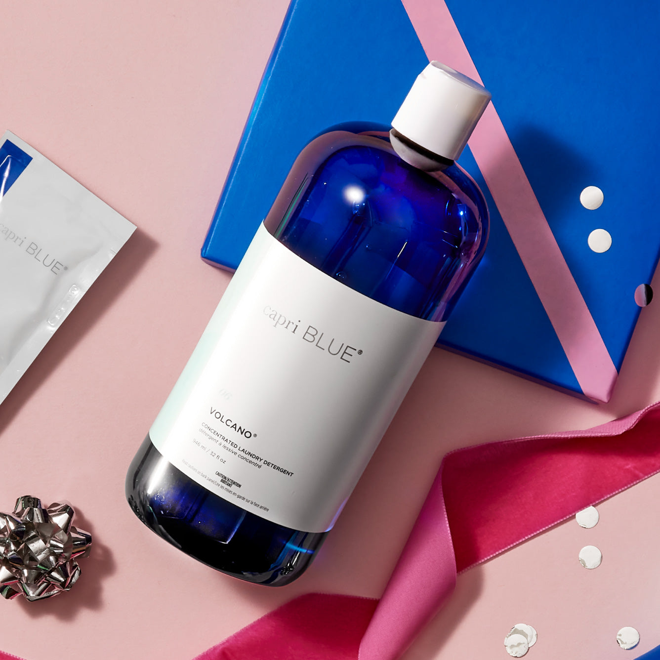 Volcano Concentrated Laundry Detergent on a pink background with ribbons and bows