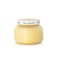 Yellow candle in a glass jar with 'Isla Bloom' branding on a white background