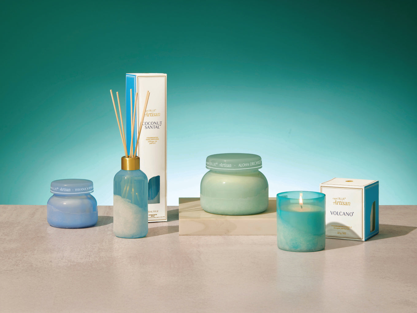 Collection of decorative items including candles and diffusers on a teal background