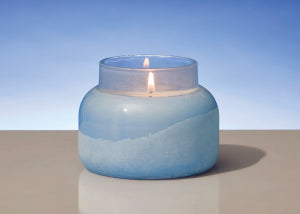 Blue candle in a glass jar with a blue background