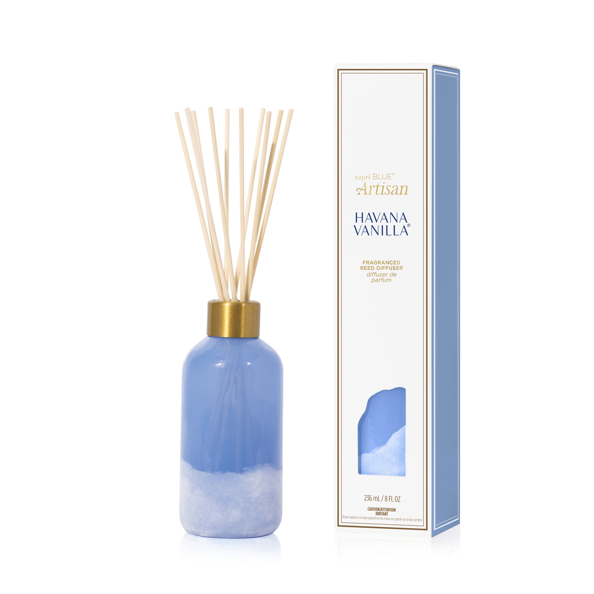 Reed diffuser with blue bottle and gold cap next to its packaging on a white background