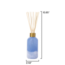 Blue diffuser bottle with reeds on a white background