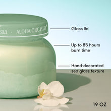 Green candle jar with 'Aloha Orchid' branding, featuring text about its features.