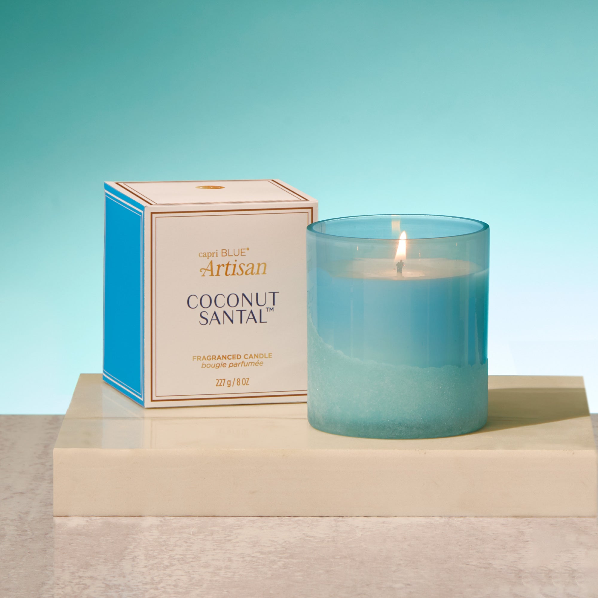 Coconut Santal candle with packaging on a light blue background