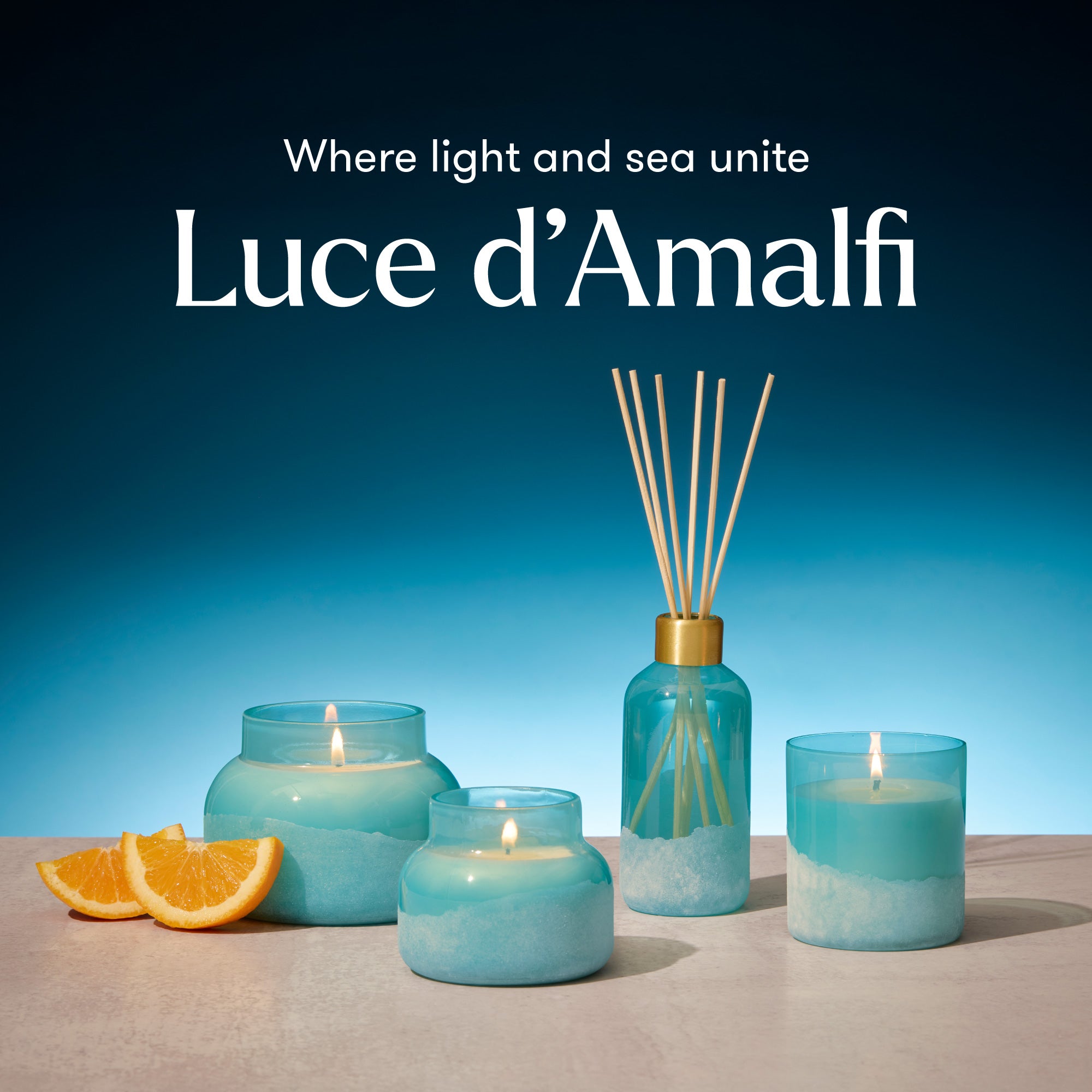 Luce d'Amalfi candles and diffuser with oranges on a blue gradient background