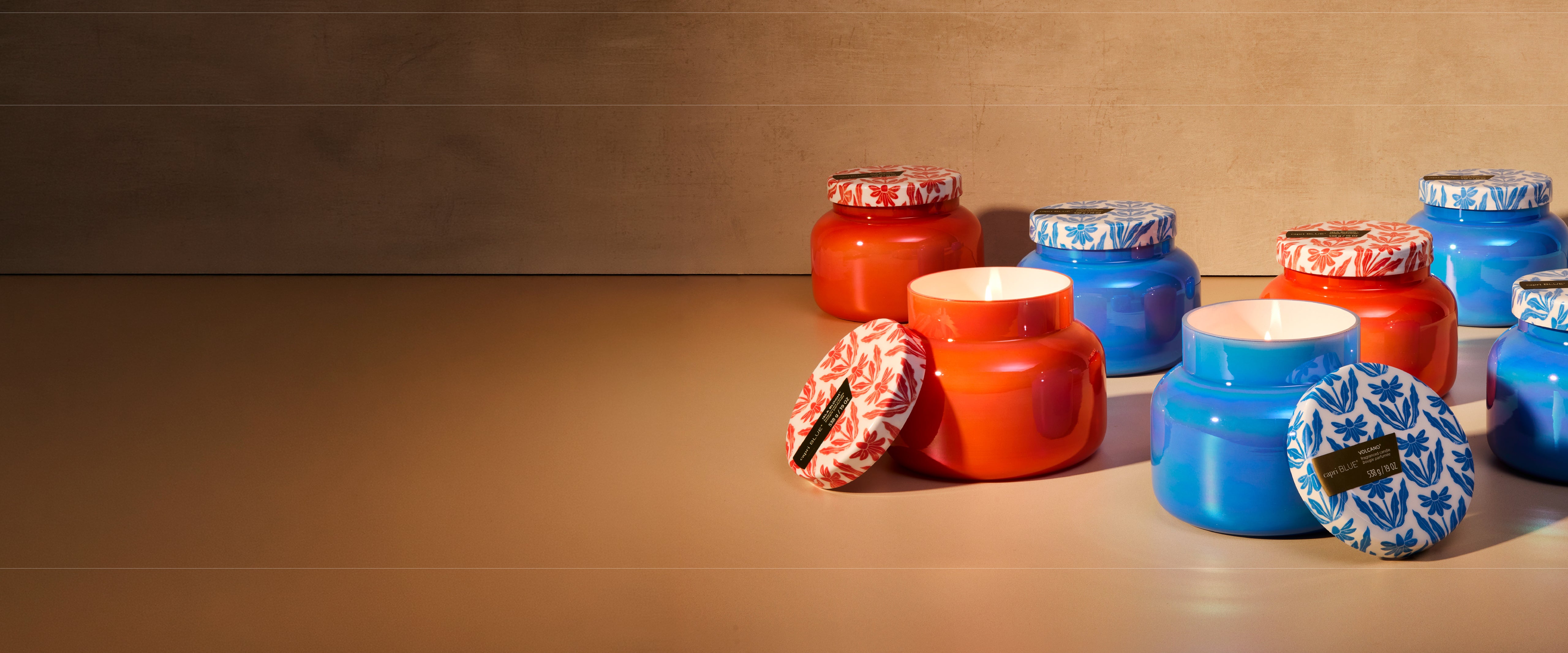 Colorful jars with decorative lids on a wooden surface