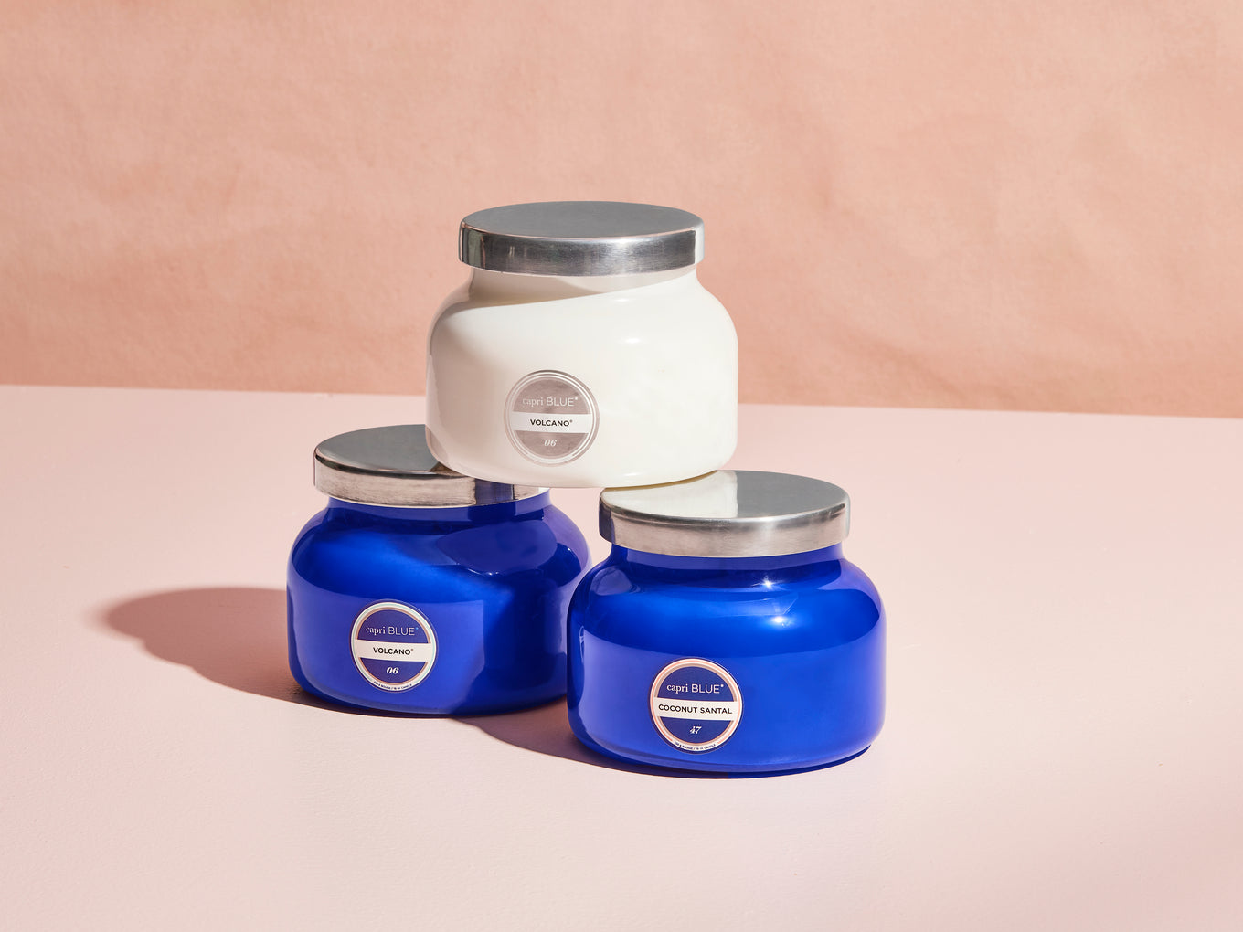 Three jars with silver lids on a beige background