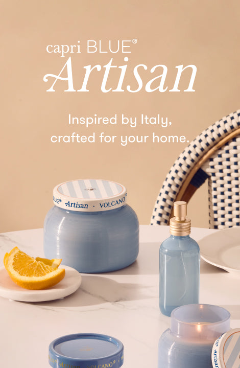 capri BLUE Artisan products on a table with an orange slice, featuring the brand's tagline.