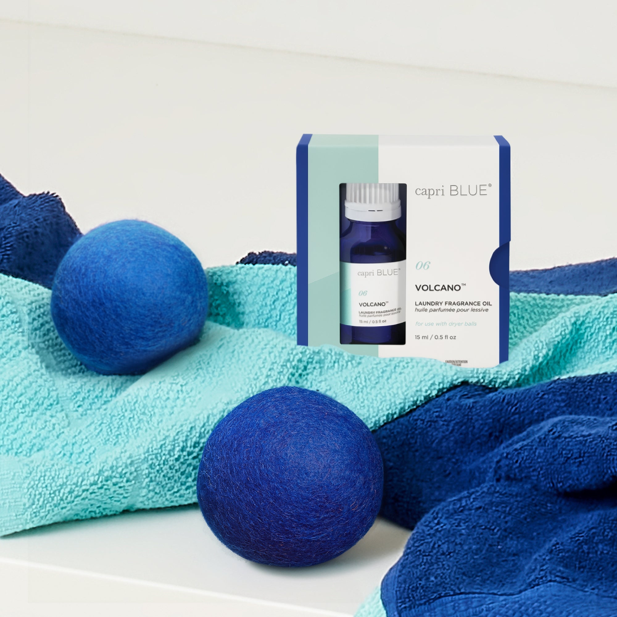 Blue laundry balls and capri BLUE Volcano laundry fragrance oil packaging on a white background