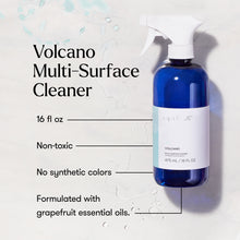 Blue spray bottle labeled 'Volcano Multi-Surface Cleaner' on a light background with text highlighting features.