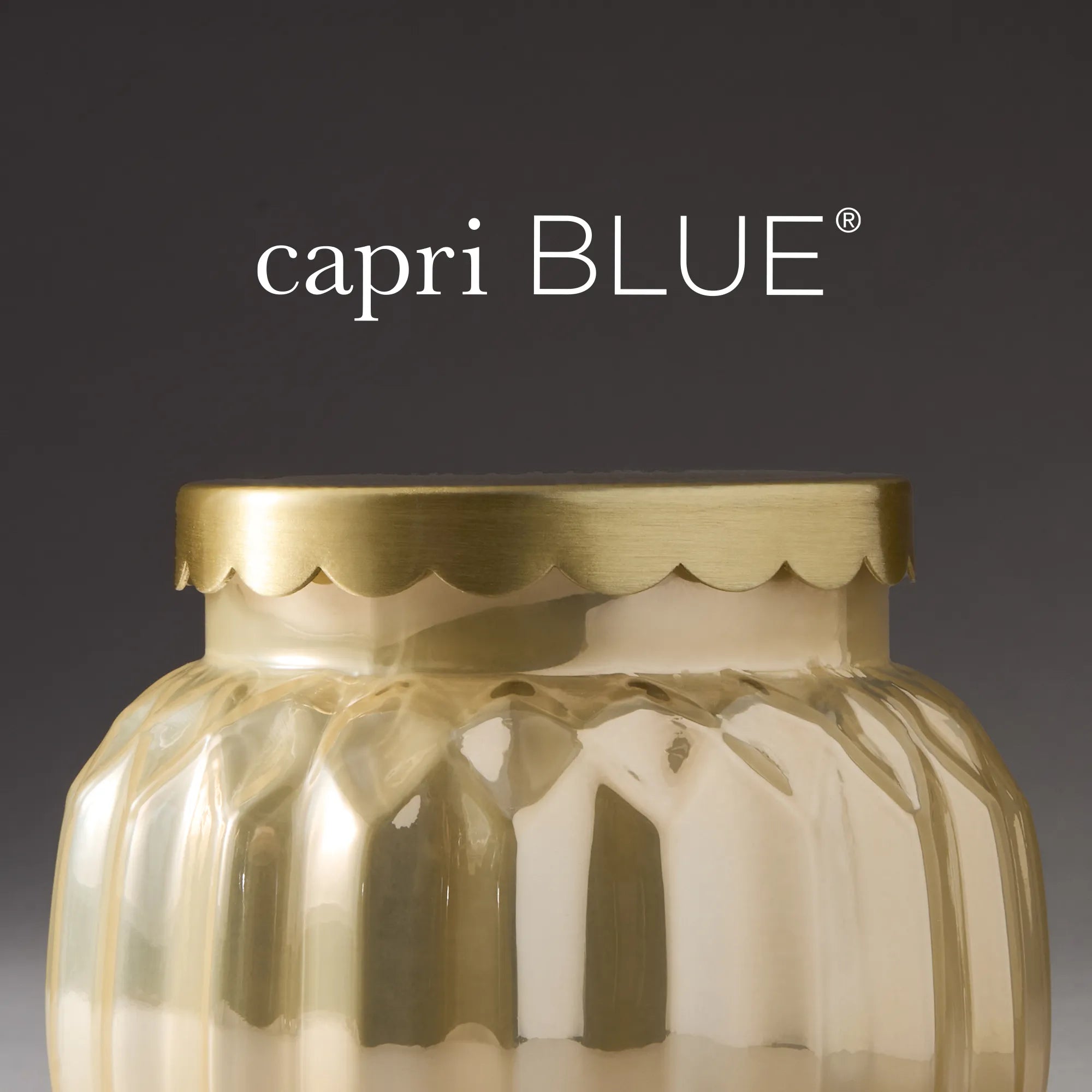 Capri Blue logo and the Cinnamon Cortado Royal Gem candle in a champagne-topaz glass jar with scalloped, gold lid.