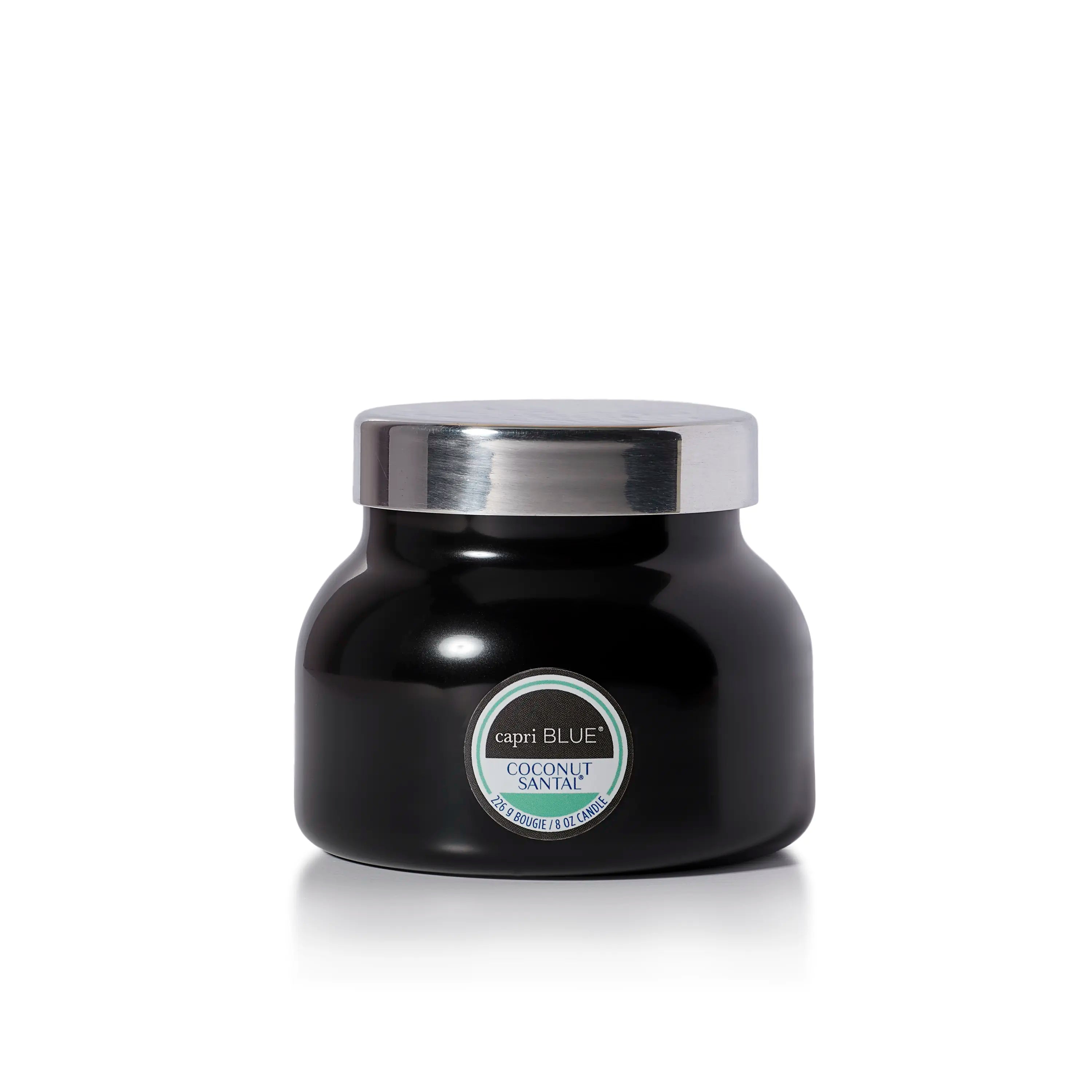 A black jar candle with a shiny silver lid and a circular label reading 'Capri Blue Coconut Scent' on a clean white background.