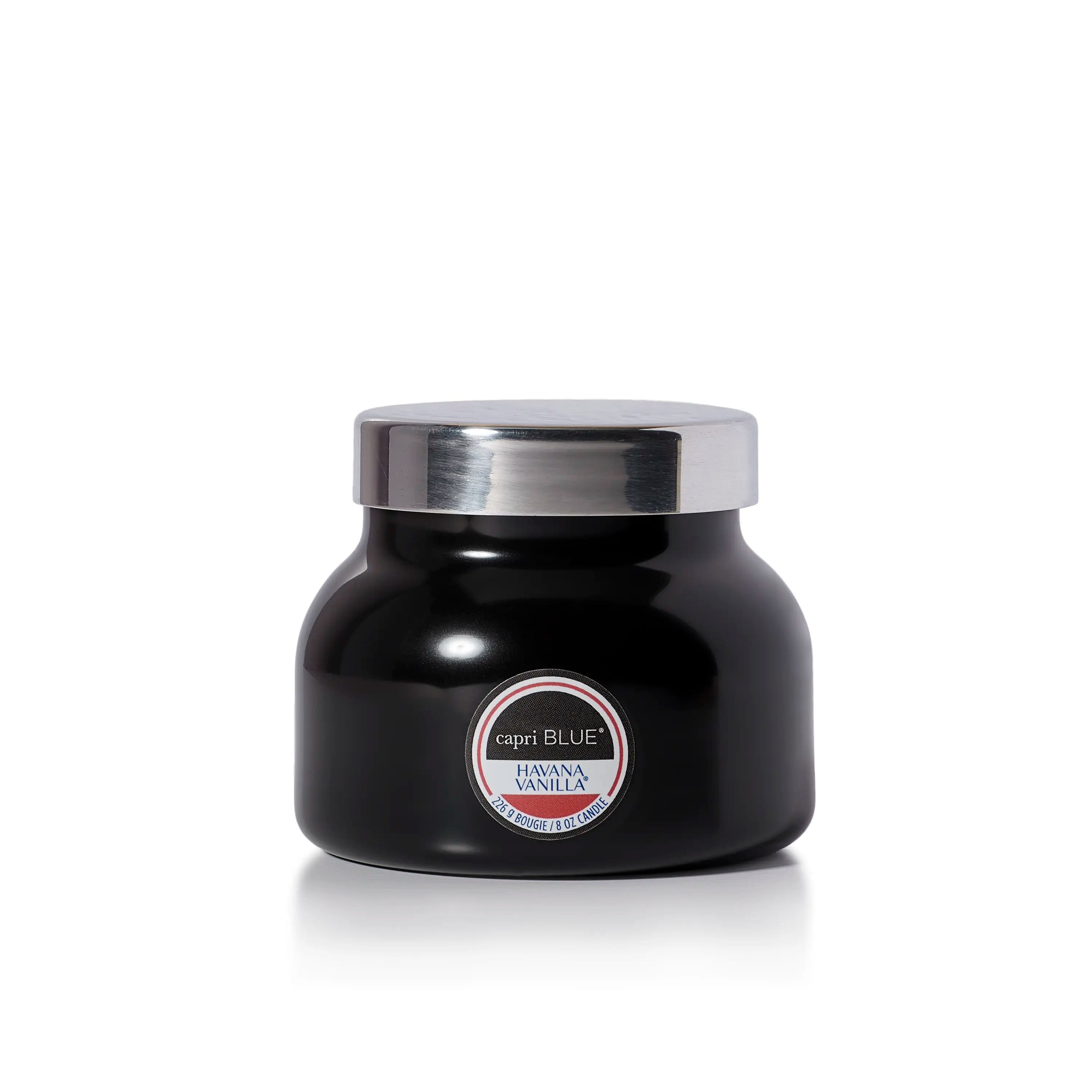 A black jar candle with a shiny silver lid and a circular label reading 'Capri Blue' and 'Harissa Vanilla'.