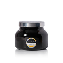 A black glass jar candle with a shiny silver lid and a circular label reading 'capri BLUE' and 'VOLCANO'.