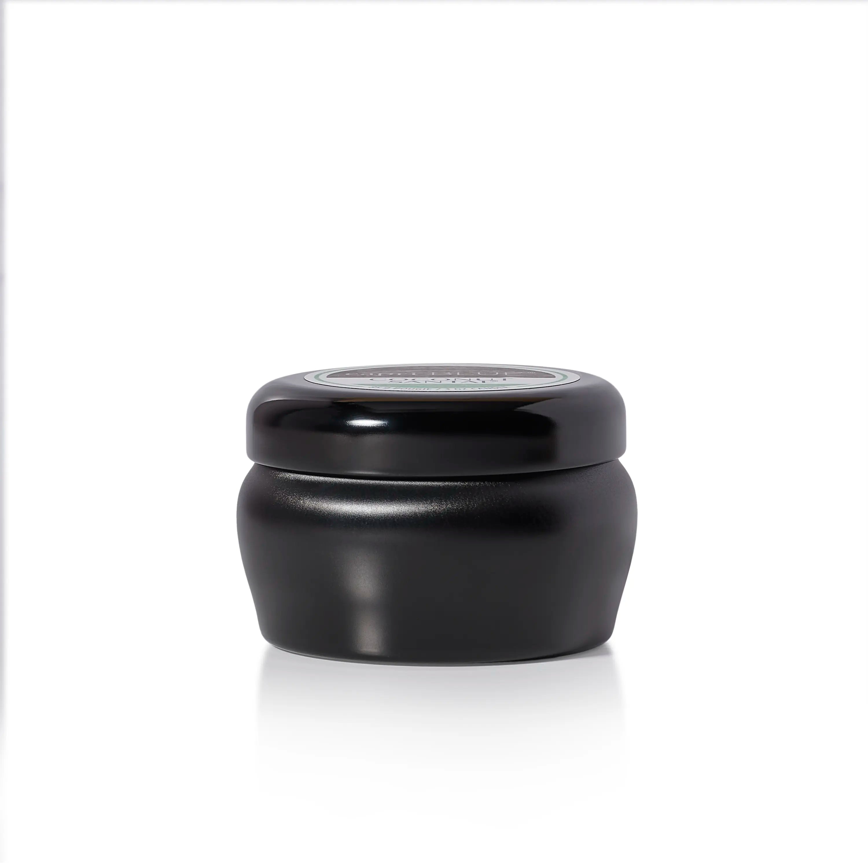 A small black candle jar with a matching black screw-top lid, photographed on a clean white background with a soft reflection underneath.