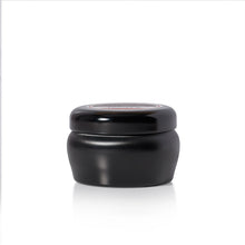 A small black candle jar with a matching black screw-top lid, photographed on a clean white background with a soft reflection underneath.