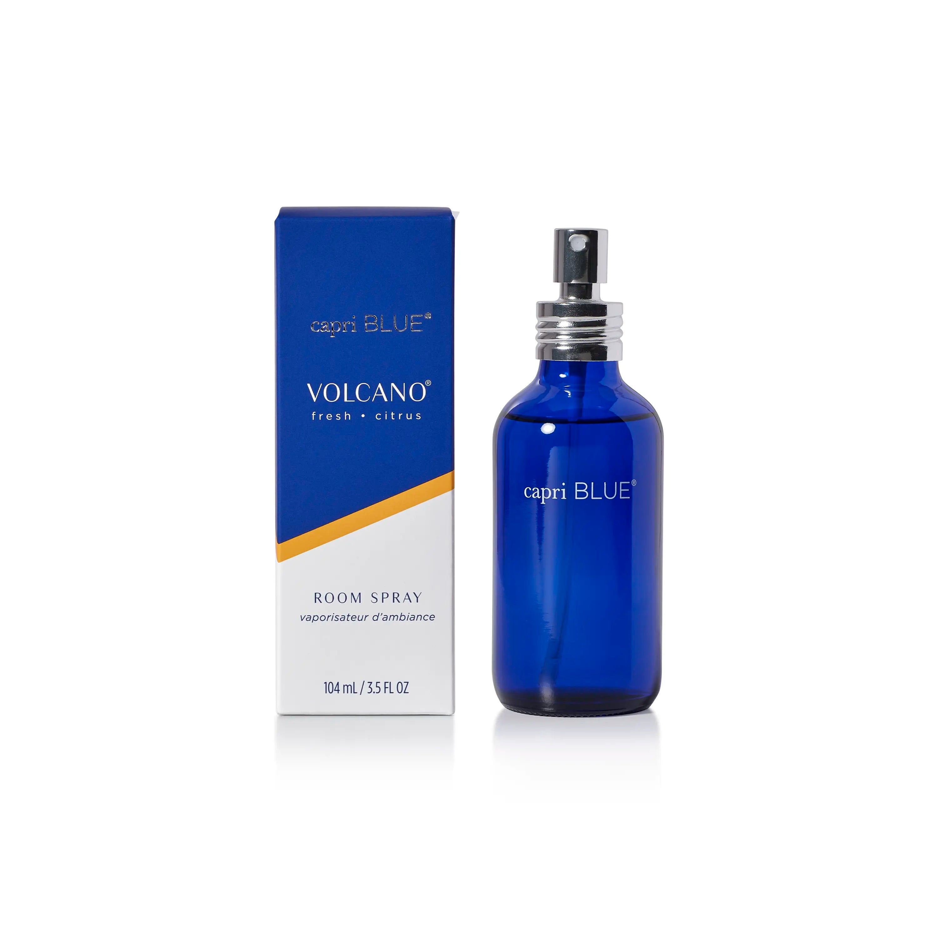 A cobalt blue glass bottle of capri BLUE Volcano Fresh + Citrus room spray stands next to its blue and white packaging box with a gold accent stripe, on a clean white background.