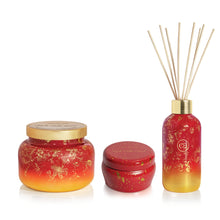 Set of red and gold scented products including a jar, small container, and diffuser on a white background.