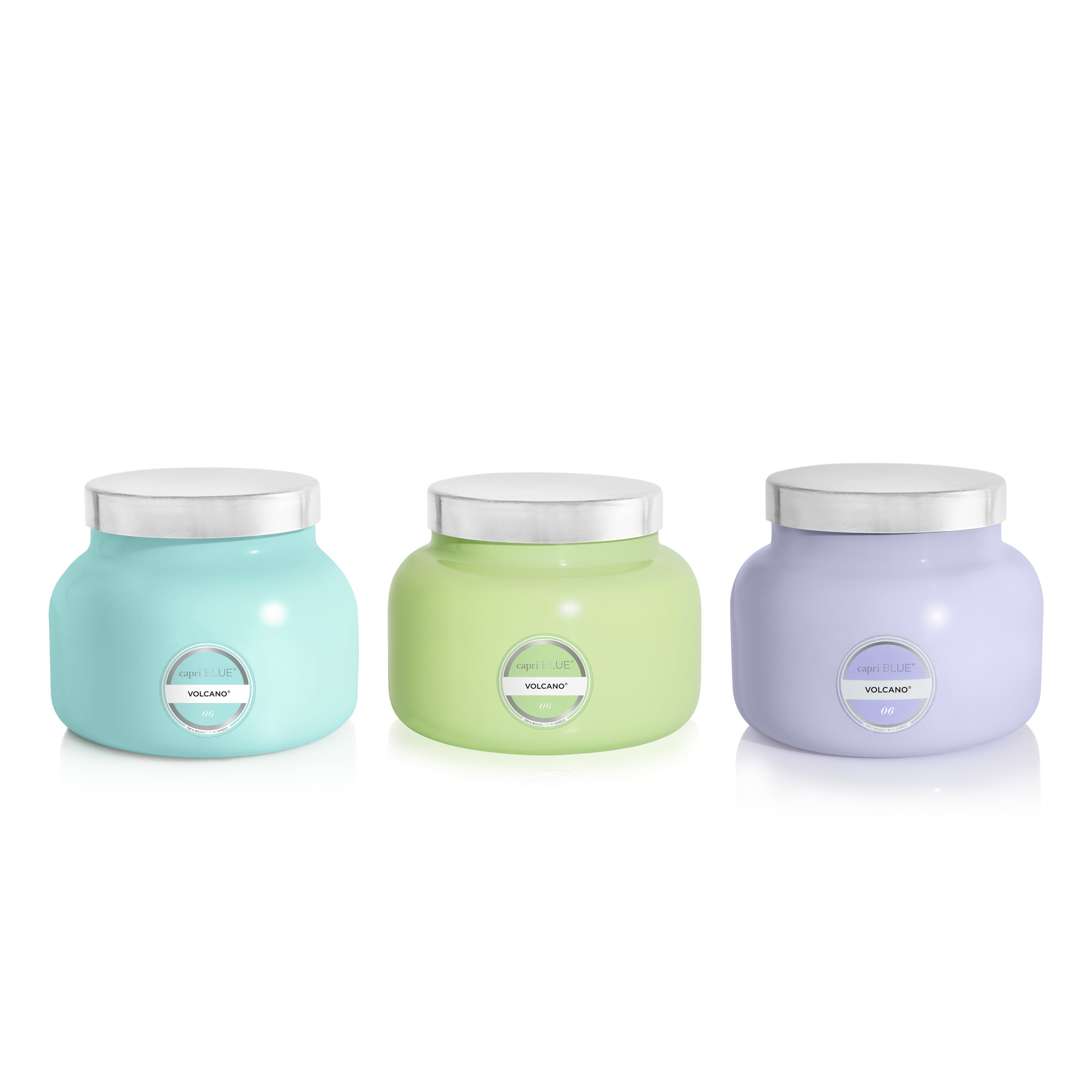 Three scented candles in different colors on a white background