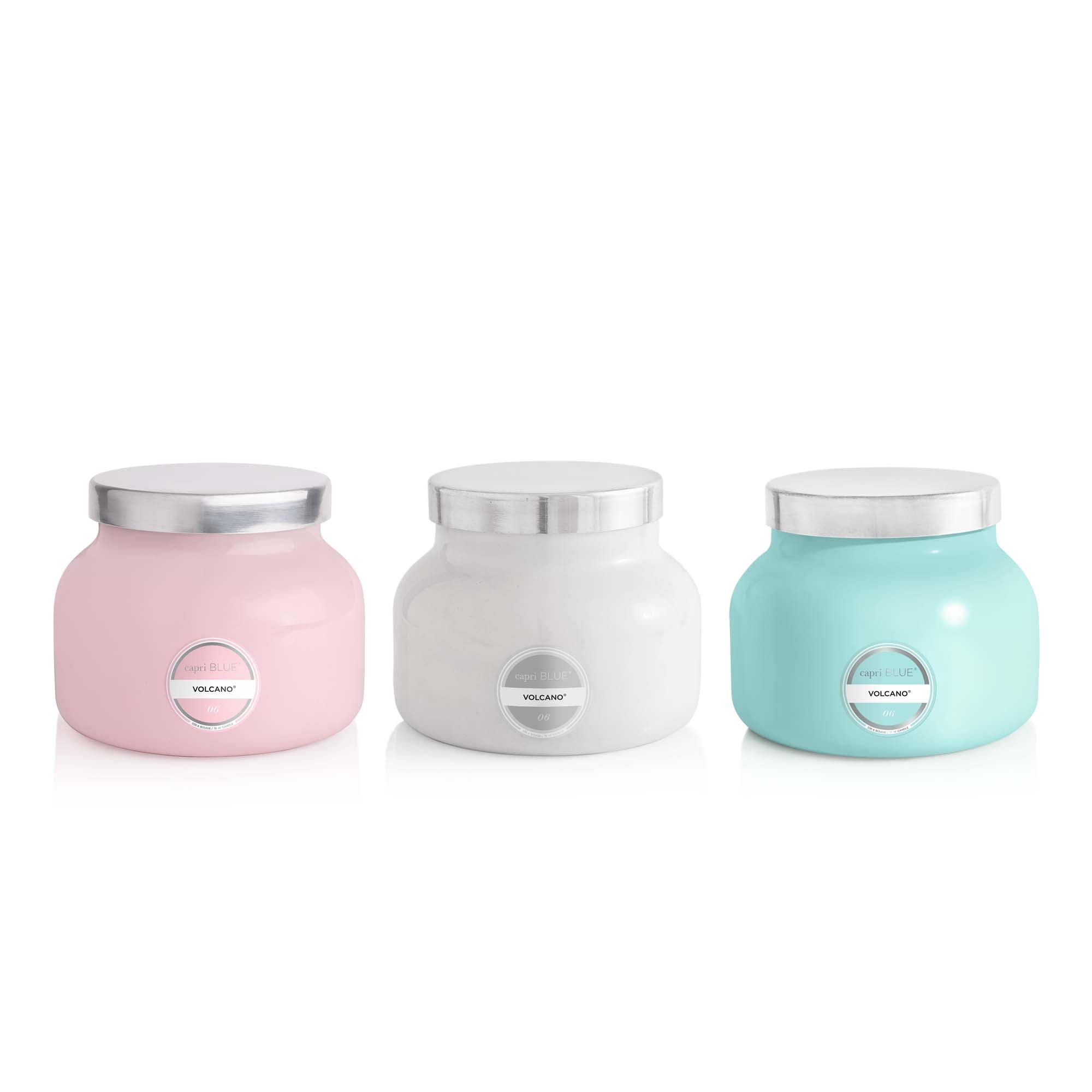 Three candles in pink, white, and blue with silver lids on a white background