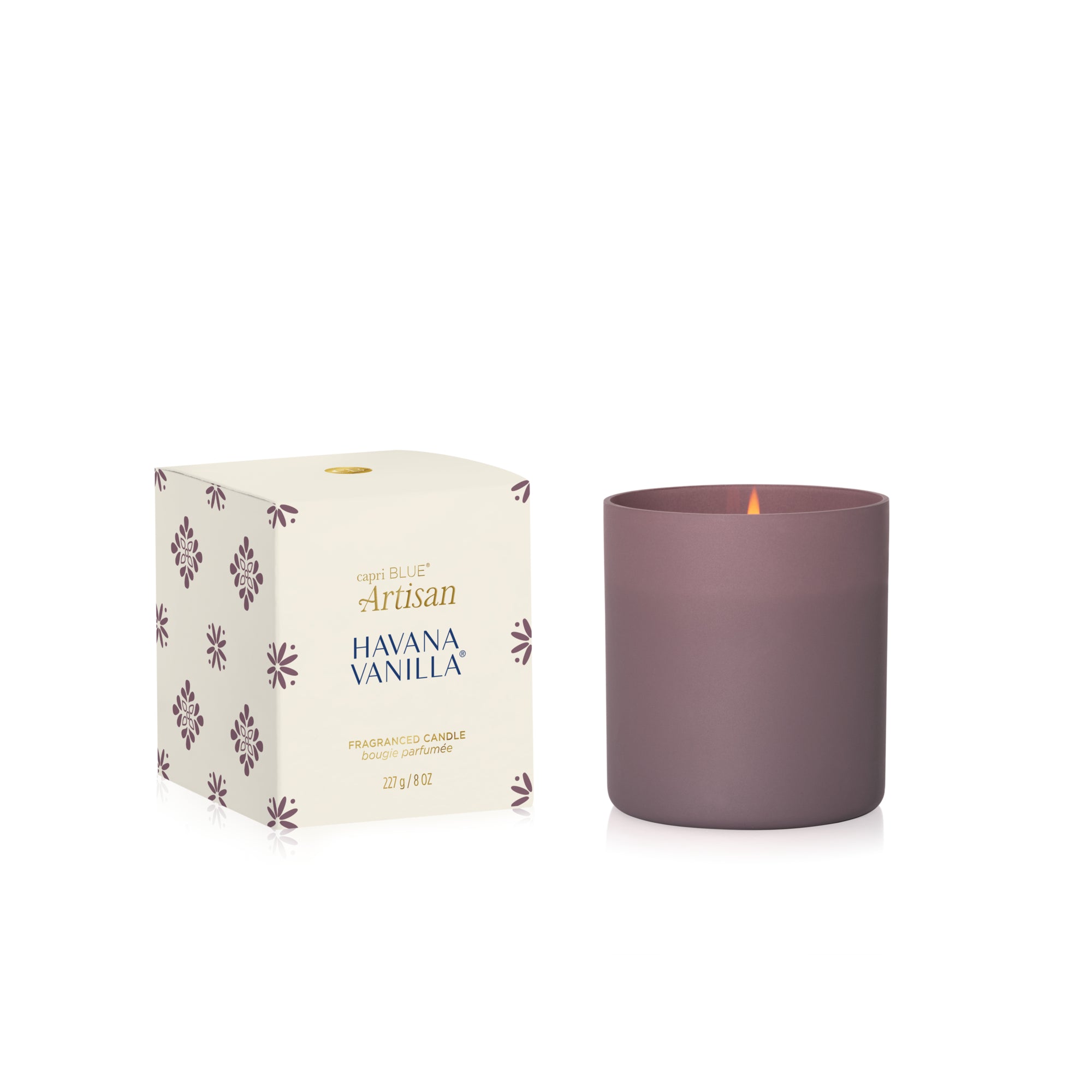 A matte mauve-pink glass candle next to its cream-colored packaging box with floral patterns. The box is labeled 'Artisan Havana Vanilla' and features a small gold logo at the top.