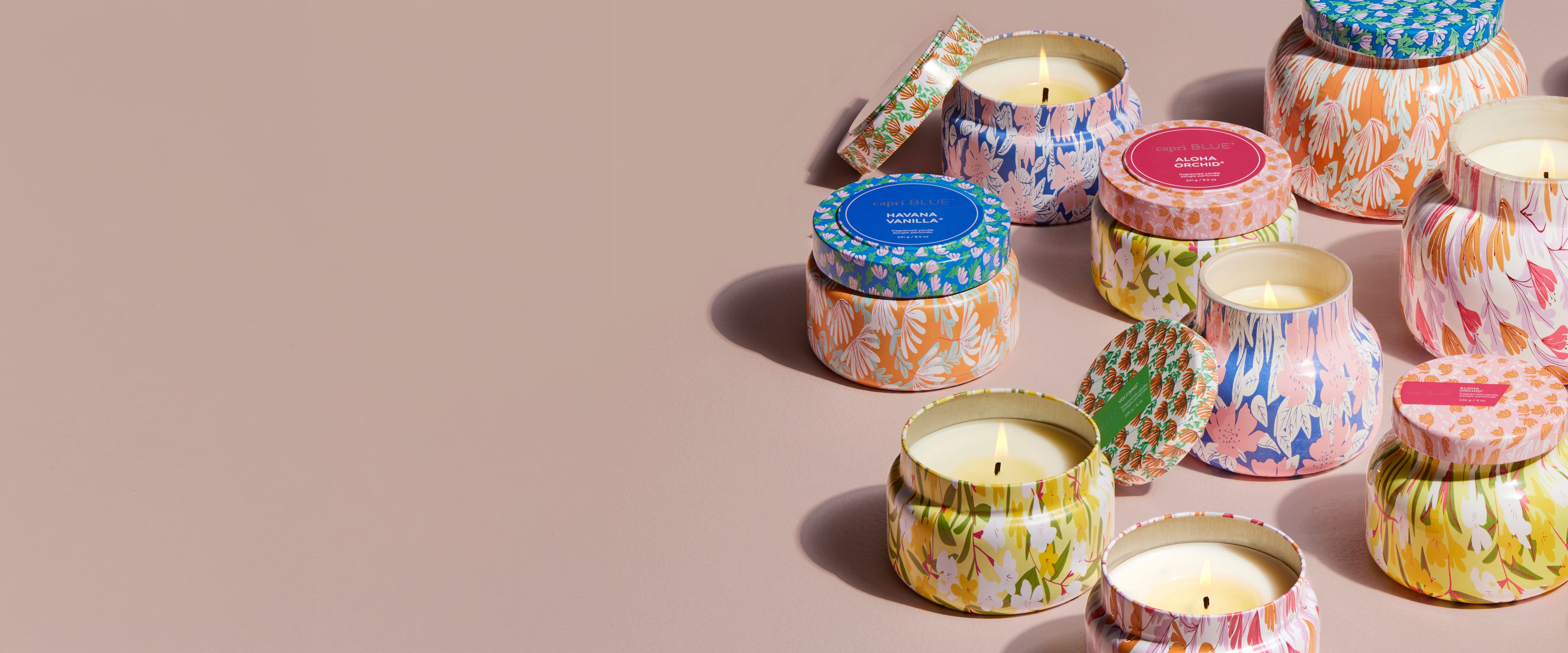 Colorful candles with decorative lids on a beige background