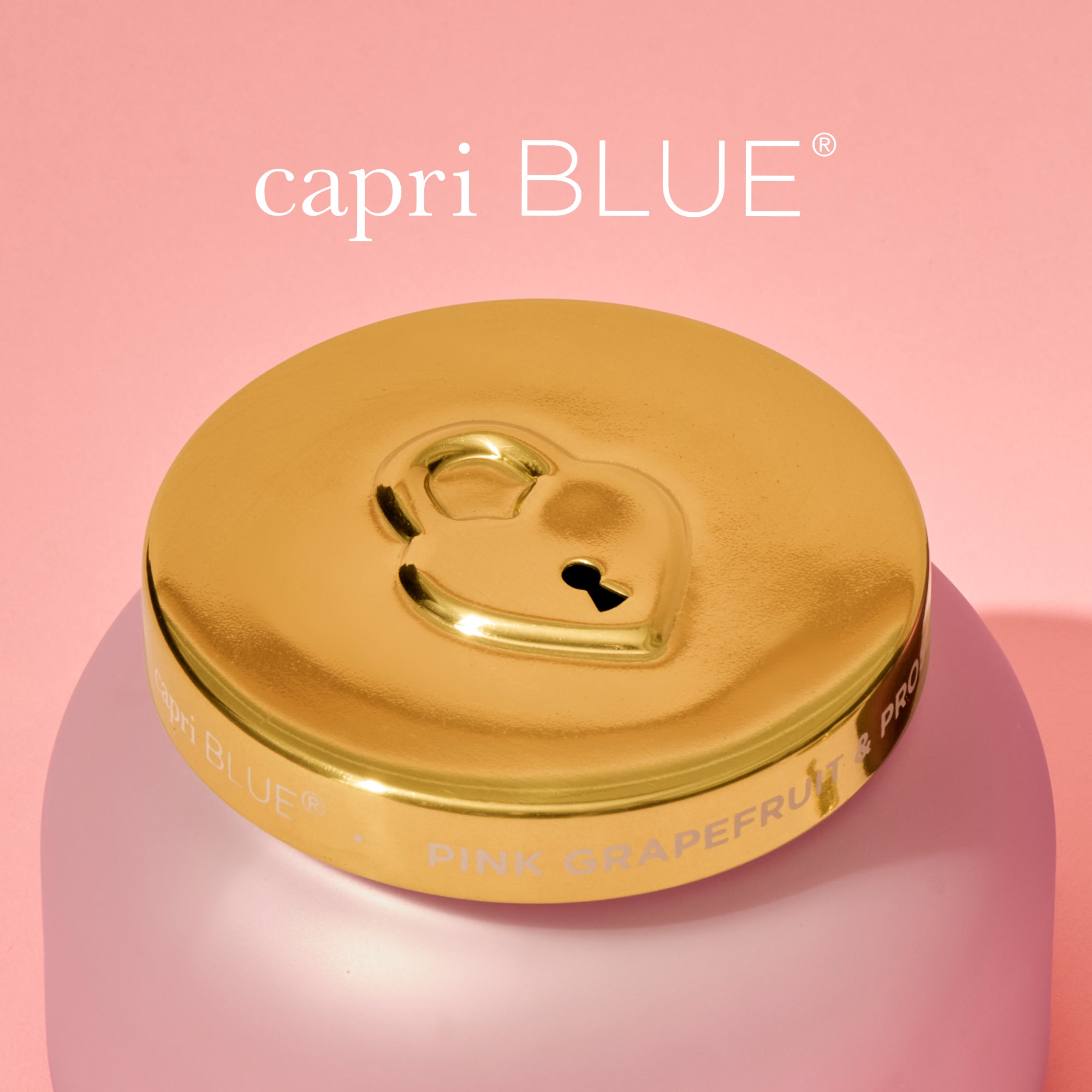 Capri Blue jar with gold lid on a pink background